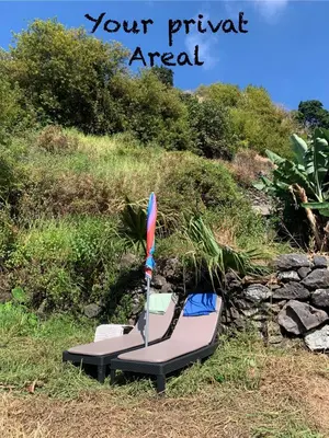 a pair of beach chairs sitting on the grass at Pico Paraiso Madeira in Ponta do Sol