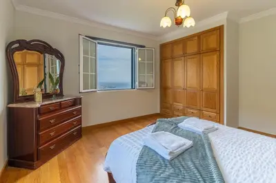 a bedroom with a bed and a dresser and a mirror at Varandas da Caldeira by Madeira ReAL in Câmara de Lobos