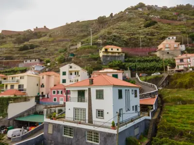 a group of houses on a hill with a mountain at Varandas da Caldeira by Madeira ReAL in Câmara de Lobos