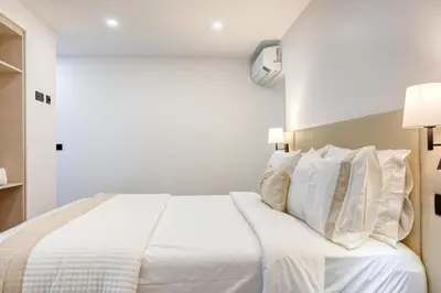 a bedroom with a white bed with white pillows at BSE15 Apartments 1A, a Home in Madeira in Funchal