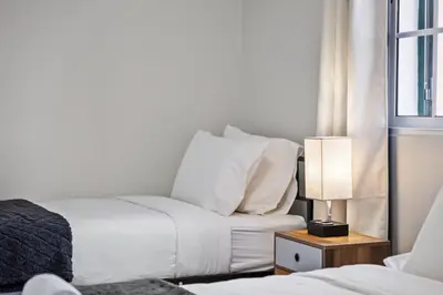 a bedroom with two beds and a lamp and a window at Ocean Flyby in Gaula