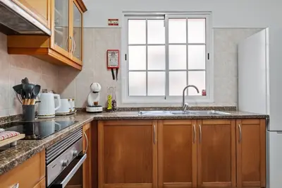 a kitchen with wooden cabinets and a sink and a window at Ocean Flyby in Gaula