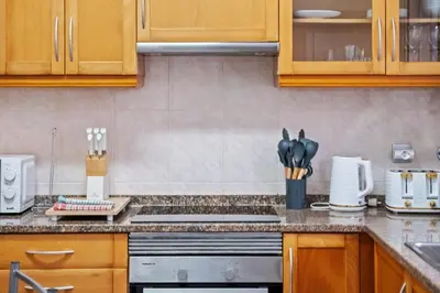 a kitchen with wooden cabinets and a stove top oven at Ocean Flyby in Gaula