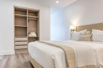 a white bedroom with a large bed and shelves at BSE15 Apartments 3I, a Home in Madeira in Funchal