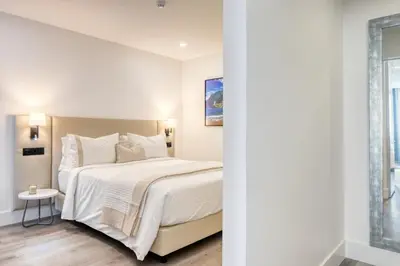 a white bedroom with a large bed and a window at BSE15 Apartments 3I, a Home in Madeira in Funchal