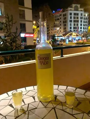 a bottle of alcohol sitting on a table with two glasses at Pakisa-Holidays in Funchal
