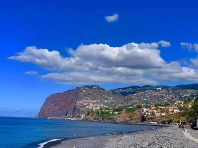 a beach in positano with a mountain in the background at Pakisa-Holidays in Funchal