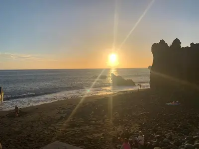 a group of people on a beach at sunset at Pakisa-Holidays in Funchal