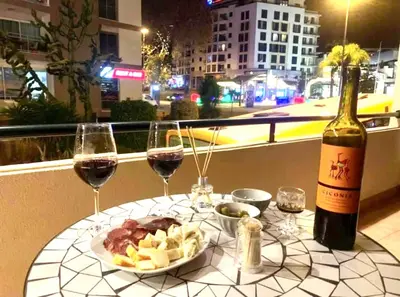 a table with two glasses of wine and a plate of food at Pakisa-Holidays in Funchal