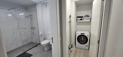 a bathroom with a shower and a washing machine at TIME OFF Madeira in Funchal