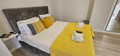 a bedroom with a large bed with a yellow blanket at TIME OFF Madeira in Funchal