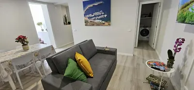 a living room with a gray couch and yellow pillows at TIME OFF Madeira in Funchal