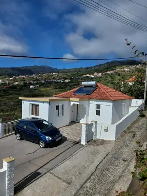 a blue car parked in front of a white house at Casa Kiri in Calheta