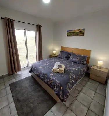 a bedroom with a bed with a bag on it at Casa Kiri in Calheta