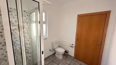 a bathroom with a toilet and a glass door at Casa Kiri in Calheta