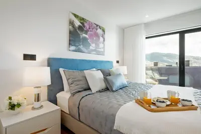 a bedroom with a bed with a tray of orange juice at City View Condo in Funchal