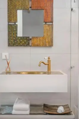 a bathroom sink with a gold faucet and a mirror at Atelier by Real Vision in Funchal