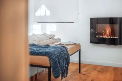 a room with a fireplace and a table with a blanket at Atelier by Real Vision in Funchal