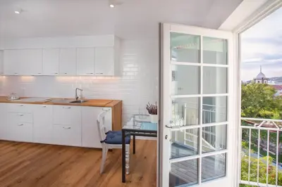 a kitchen with white cabinets and a table and a window at Atelier by Real Vision in Funchal