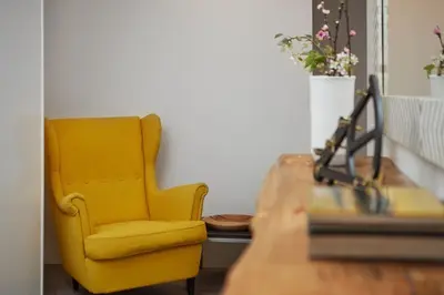 a yellow chair sitting next to a wooden table at DOMO by Real Vision in Funchal