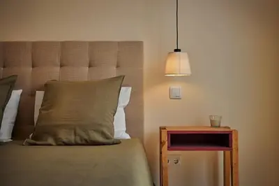 a bed with a pillow and a night stand with a lamp at DOMO by Real Vision in Funchal