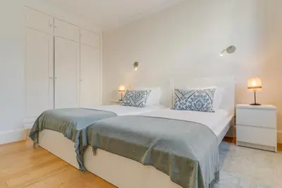 two beds in a bedroom with white walls and wood floors at Sublime View Villa by Atlantic Holiday in Funchal