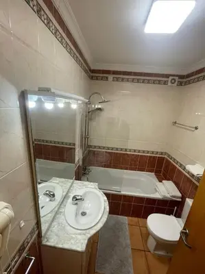a bathroom with a sink and a toilet and a tub at Superbe appartement vue mer et falaises in Lagos
