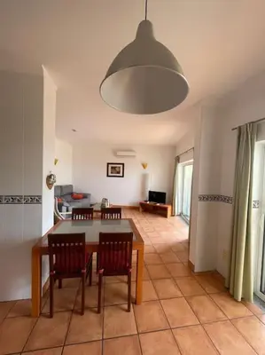 a living room with a dining room table and chairs at Superbe appartement vue mer et falaises in Lagos