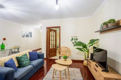 a living room with a blue couch and a tv at Cantinho dos Netos in Funchal