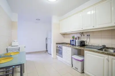 a kitchen with white cabinets and a blue counter top at Cantinho dos Netos in Funchal