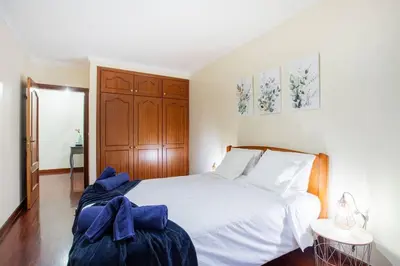 a bedroom with a white bed with a blue bow on it at Cantinho dos Netos in Funchal