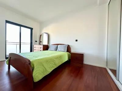 a bedroom with a large bed with a blue blanket at Rooms for Rent in Funchal in Funchal