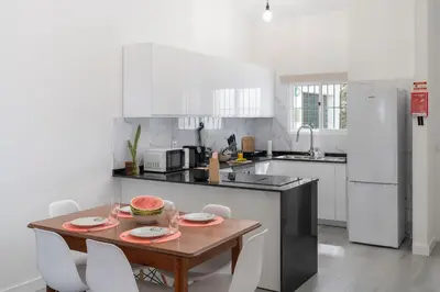 a kitchen with a wooden table and white appliances at Casa Areia Dourada by An Island Apart in Porto Santo