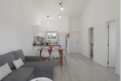 a living room and kitchen with a couch and a table at Casa Areia Dourada by An Island Apart in Porto Santo