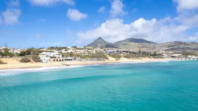a view of a beach with mountains in the background at Casa Areia Dourada by An Island Apart in Porto Santo