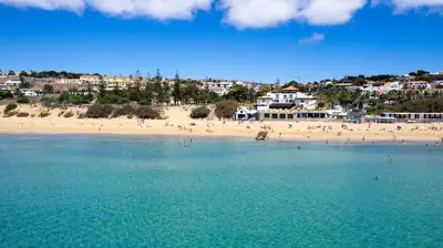 a beach with a bunch of people in the water at Casa Areia Dourada by An Island Apart in Porto Santo