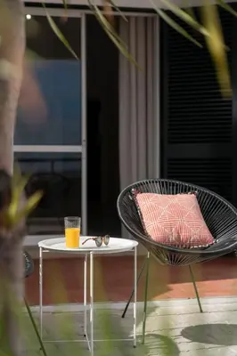a chair and a table with a drink on a patio at Casa Areia Dourada by An Island Apart in Porto Santo
