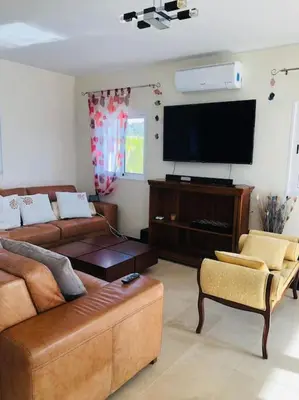 a living room with a couch and a flat screen tv at DAR Arrifana- Stylish 4-Bedroom Villa -Ocean Views in Aljezur