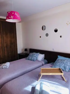 a bedroom with two beds and a pink lamp at DAR Arrifana- Stylish 4-Bedroom Villa -Ocean Views in Aljezur