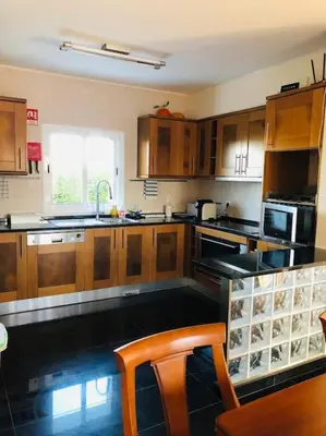 a kitchen with wooden cabinets and a counter top at DAR Arrifana- Stylish 4-Bedroom Villa -Ocean Views in Aljezur