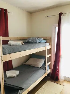 two bunk beds in a room with a window at DAR Arrifana- Stylish 4-Bedroom Villa -Ocean Views in Aljezur