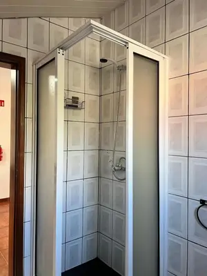 a shower with a glass door in a bathroom at Quiet Cozy Apt MQ2 & Near Beach & Mountain View in Calheta