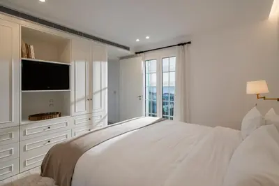a white bedroom with a large bed and a tv at Quinta Marefe - On the stunning west coast in Paul do Mar