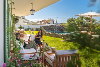 a man and a woman sitting on a patio at Quinta Marefe - On the stunning west coast in Paul do Mar