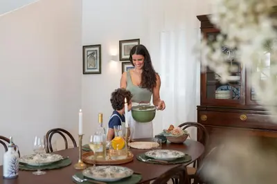 a woman and a child standing at a table preparing food at Quinta Marefe - On the stunning west coast in Paul do Mar