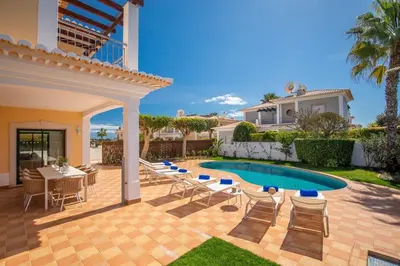 a patio with a table and chairs and a swimming pool at Paradise Beach Villa by Blue Diamond 18 in Lagos