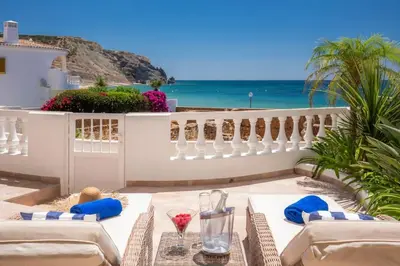 a patio with a table with a view of the ocean at Beachfront Apartment Praia da Luz by Blue Diamond 23B in Luz
