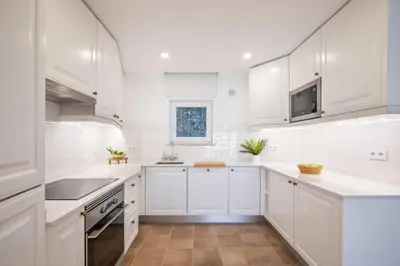 a white kitchen with white cabinets and a sink at Beachfront Apartment Praia da Luz by Blue Diamond 23B in Luz