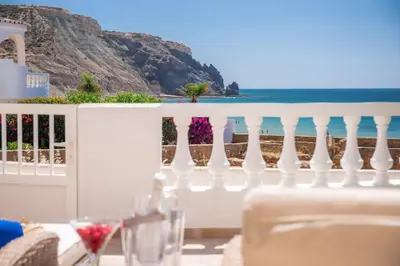 a balcony with a table and a view of the ocean at Beachfront Apartment Praia da Luz by Blue Diamond 23B in Luz