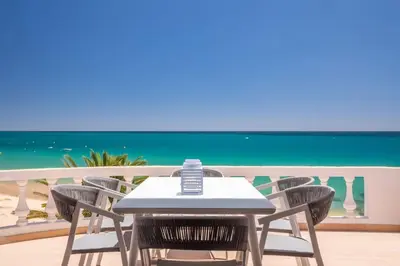 a table and chairs on a balcony with the beach at Beach View Apartment Praia da Luz by Blue Diamond 24-1F in Luz
